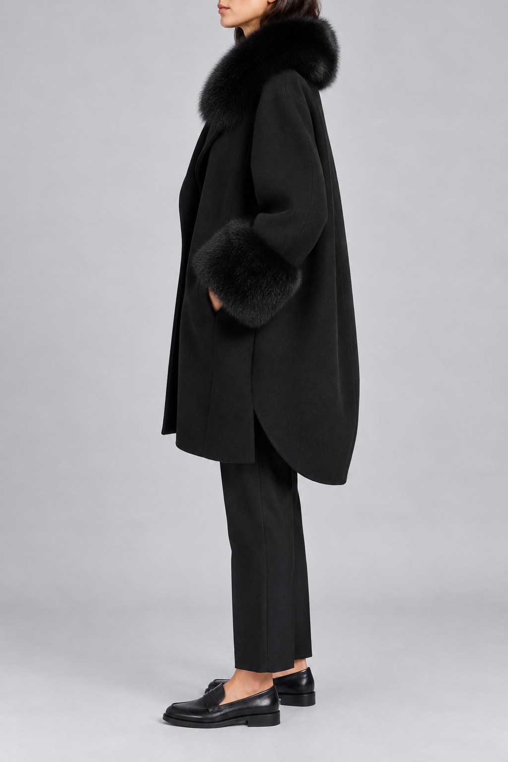 Cappotto Herno nero con finiture in pelliccia e fondo arrotondato, vista laterale